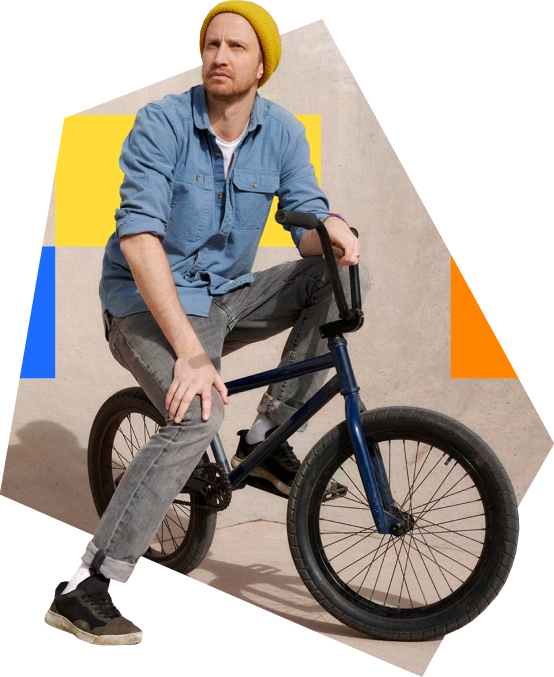 Adam Hunt, founder of Yeah Us! Games, sitting on his BMX